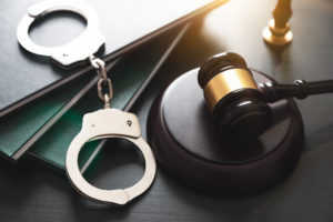 Maryland Peace and Protective Orders Lawyer with handcuffs and wooden gavel on a table